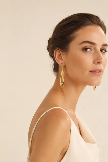 Maison Vela client wearing elongated gold earrings
